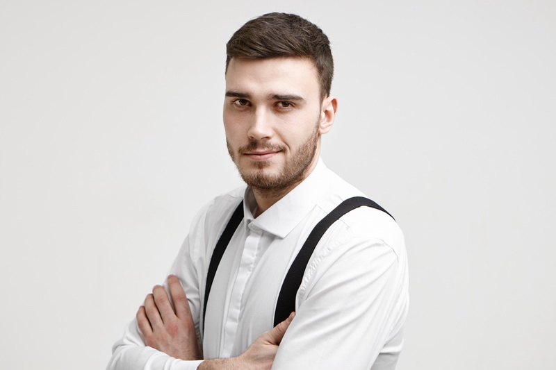 People, work, job, career and employment concept. Picture of attractive self confident prosperous young male manager posing in studio with arms crossed and staring at camera with confident smile