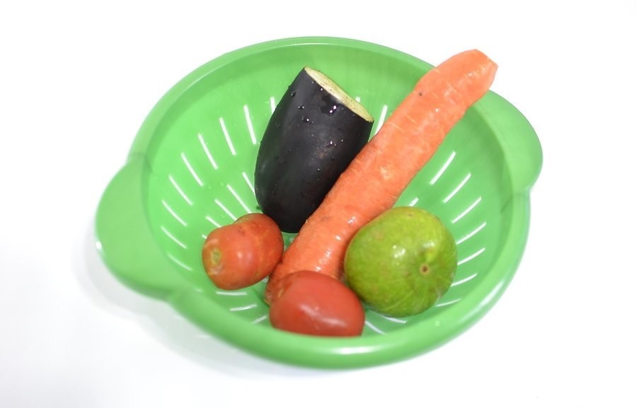 морковь, половинка баклажана и два помидора в дуршлаге